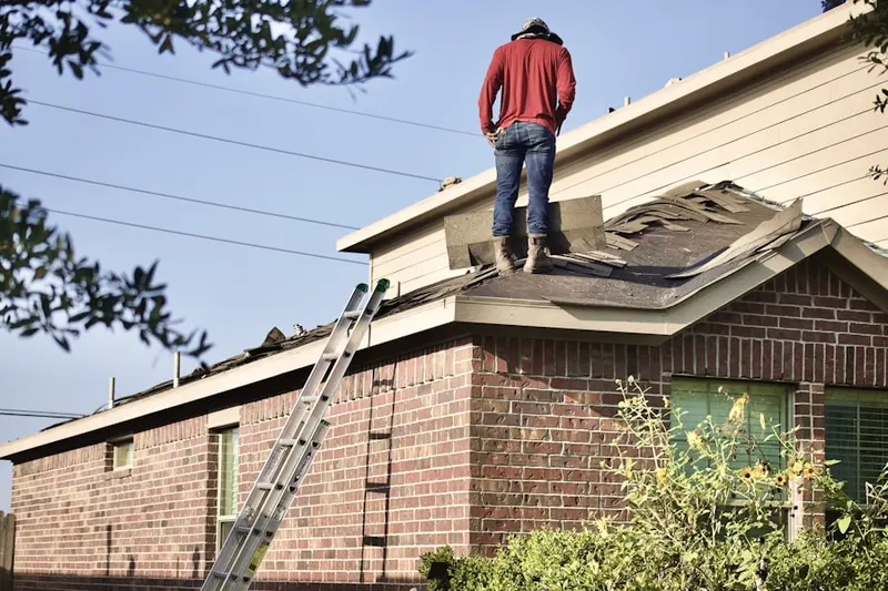 Professional roofer working on a residential roof in East Lansing